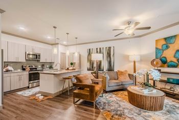A modern kitchen with a dining area and a living room.